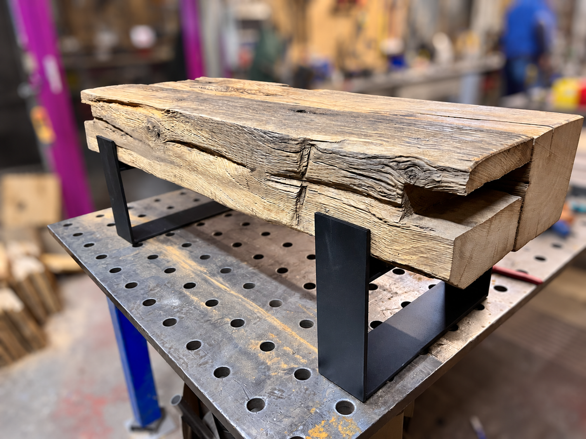 Couchtisch aus Eiche mit markanten Holzspuren und dunklem Stahlgestell auf einer Werkbank – Referenzprojekt 002