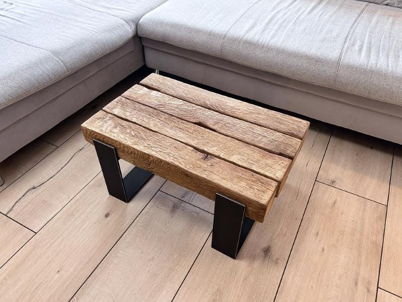 Kompakter Couchtisch aus antiker Eiche mit dunklem Stahlgestell neben einem Sofa