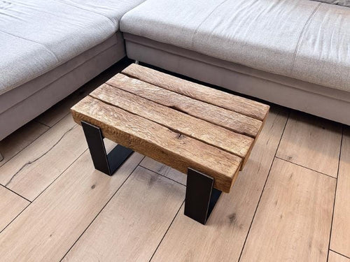 Kompakter Couchtisch aus antiker Eiche mit dunklem Stahlgestell neben einem Sofa