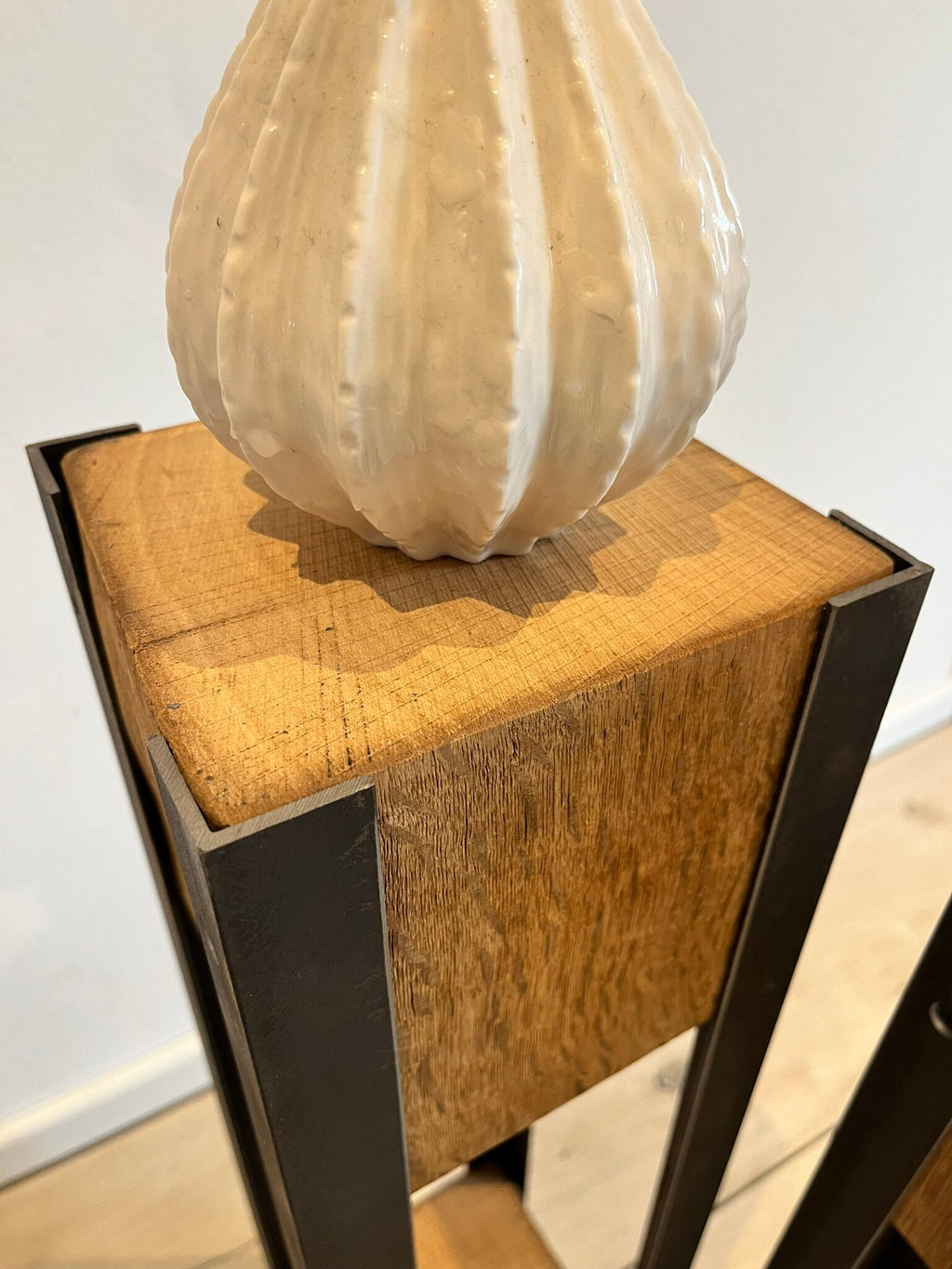 Holzoberseite einer Dekosäule aus antiker Eiche mit einer Vase als Dekoration
