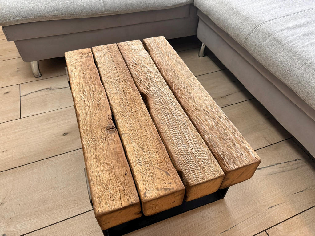Gesamtansicht des Eichenbalken-Couchtischs am Sofa mit sichtbaren Holzspuren