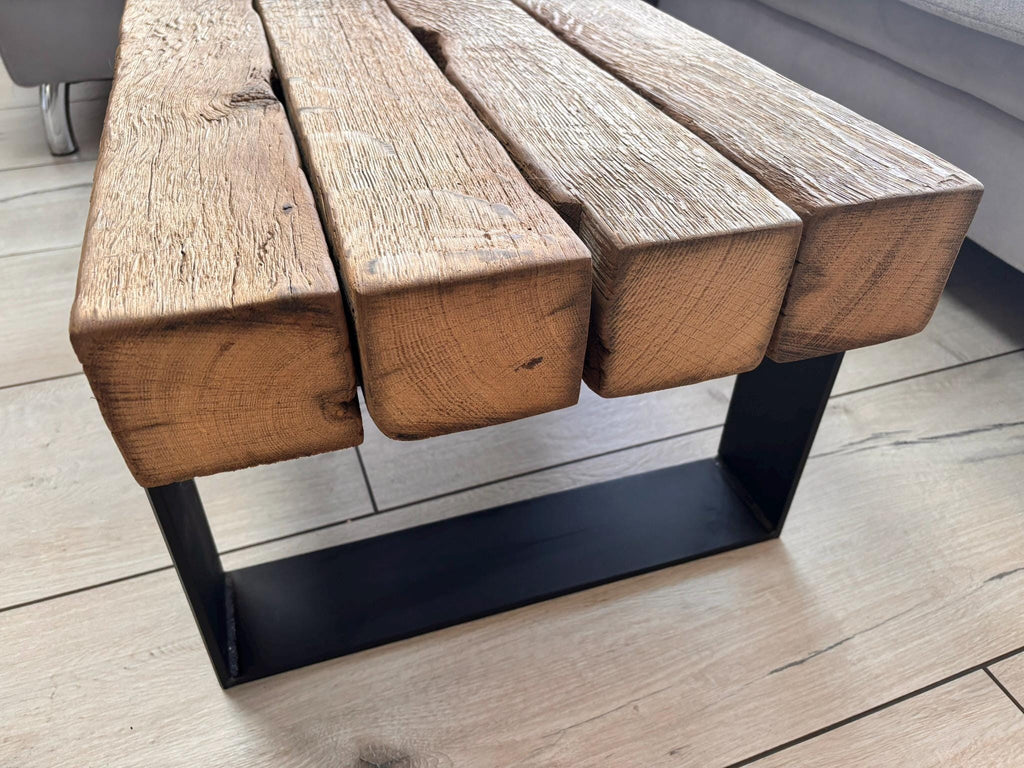 Nahansicht der Balkenstirnseiten und des dunklen Stahlgestells am Couchtisch