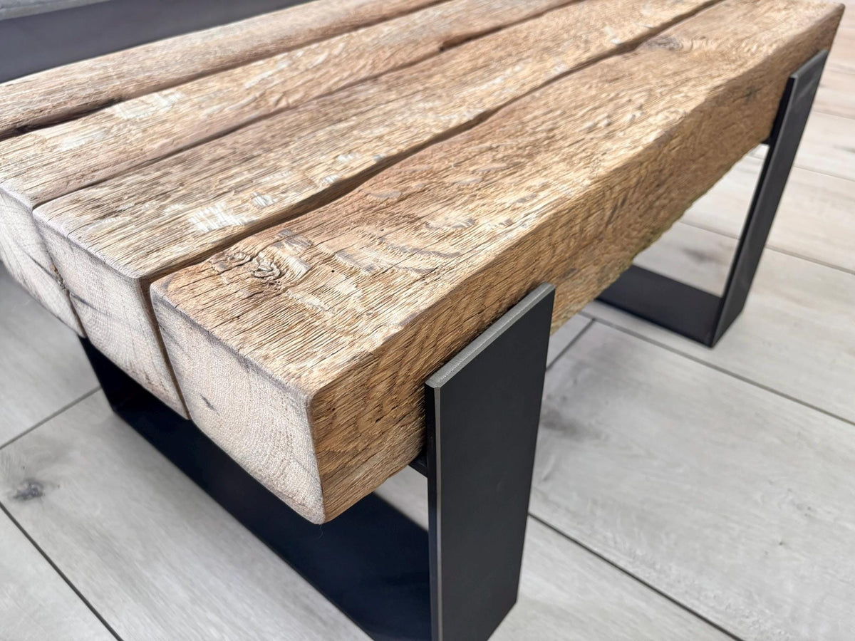 Holzkante mit sichtbarer Maserung über der geschweißten Stahlkufe des Couchtischs