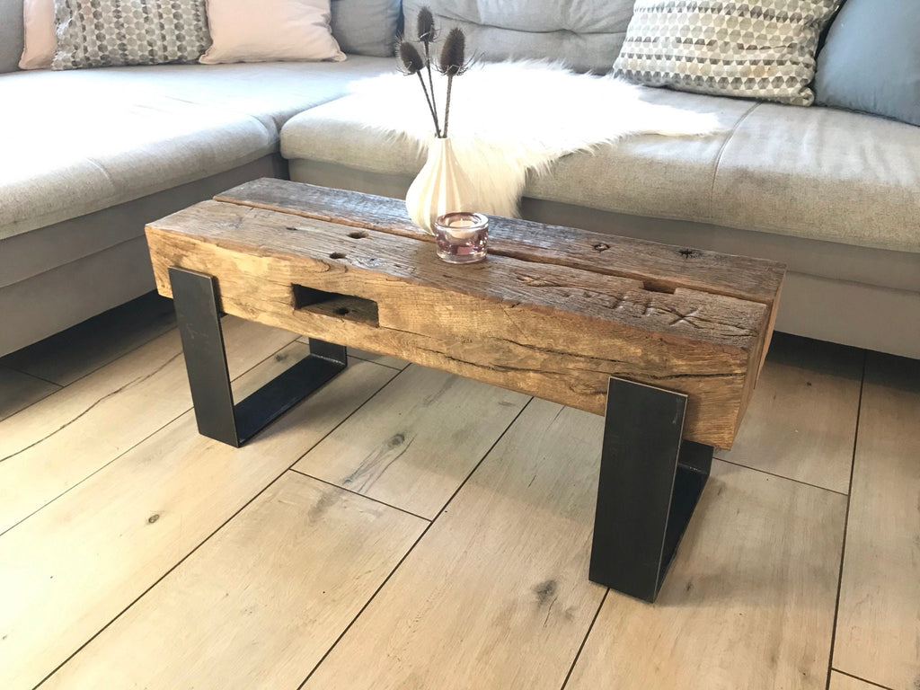 Längliche Eichenbalkenbank mit dunklem Stahlgestell vor einem Sofa