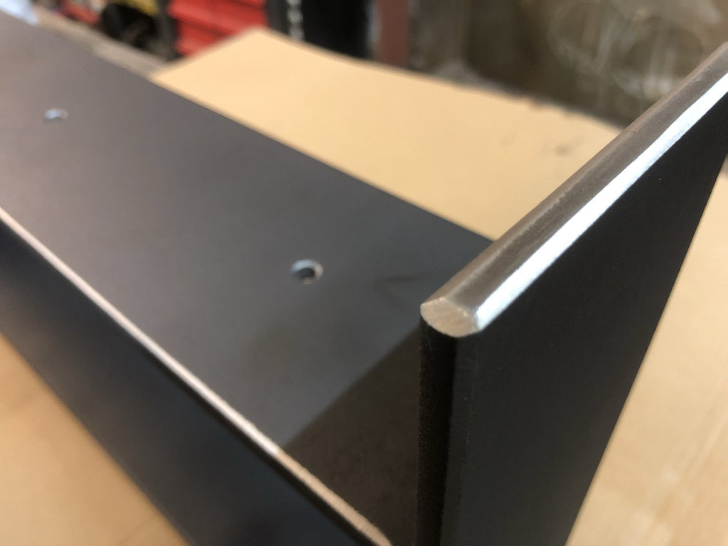Detail eines handgefertigten Stahlgestells mit Auflage und Befestigungsbohrung in der Werkstatt